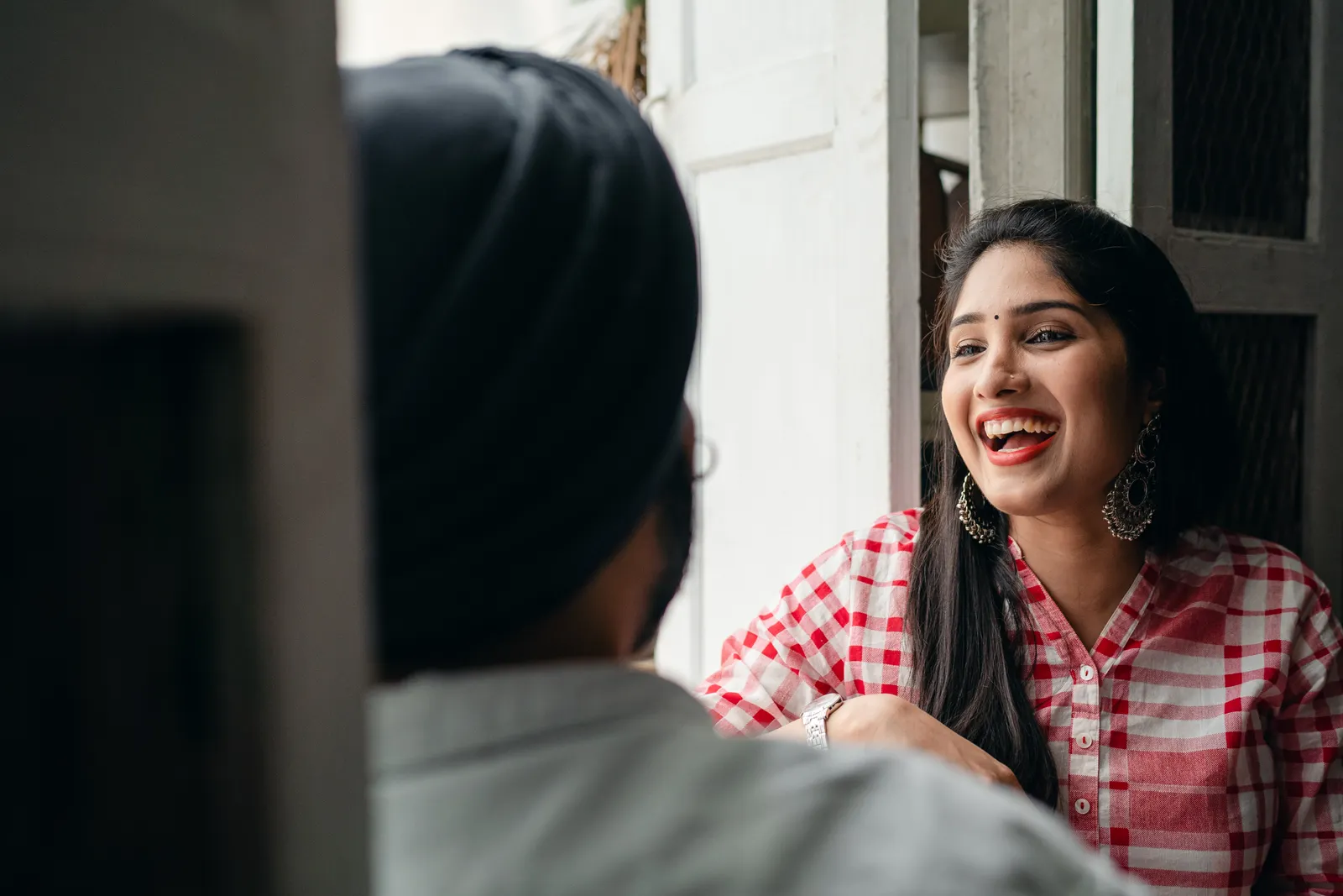 A fictional woman laughing with her partner at home